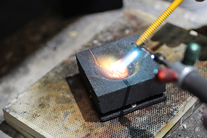 Once properly weighed out, gold and alloy are melted together in the beginning stages of creating a wedding band by hand.