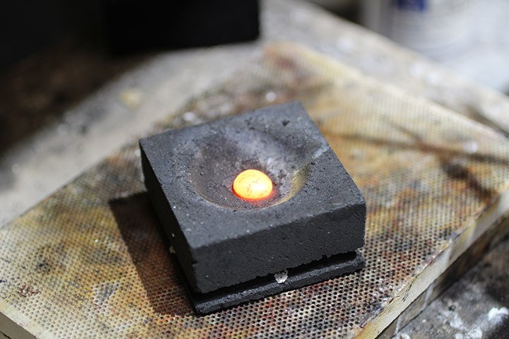 Here, the gold and alloy have been melted down and formed into an ingot—shown here red-hot.