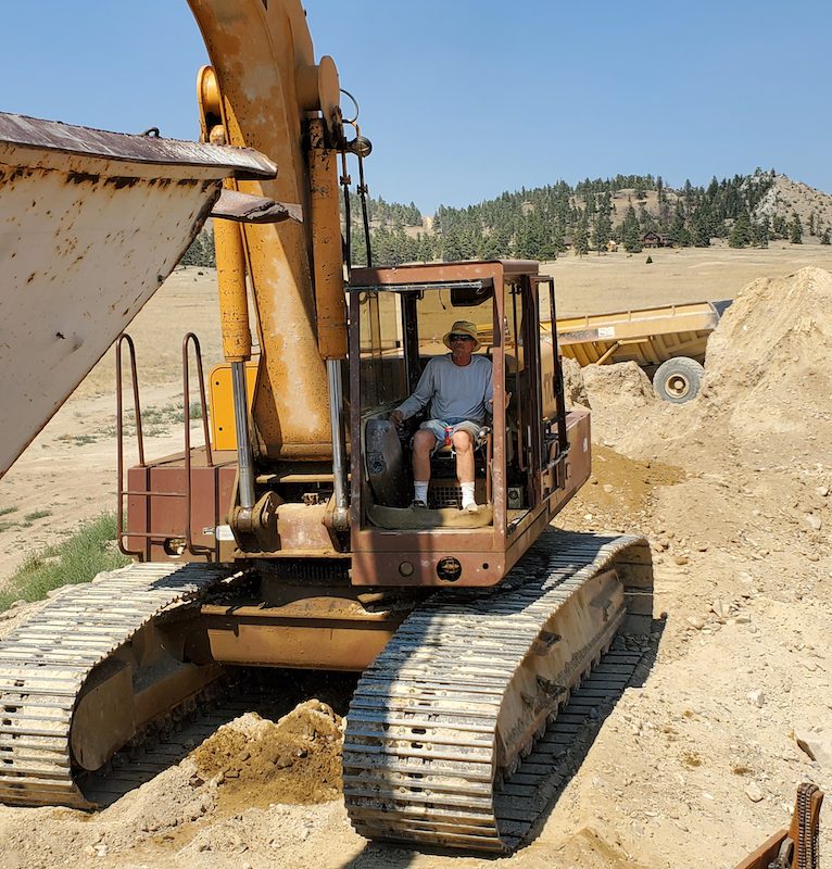 Operating a backhoe at the Montana Sapphire mine we source our stones from.